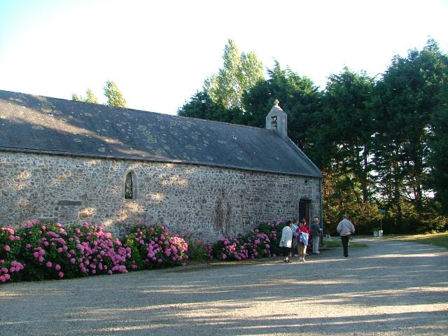 Stone chapel with pink flowering bushes outside