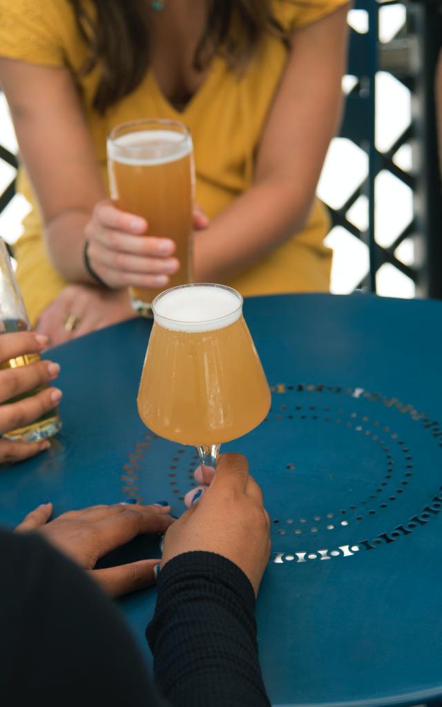 Groupe d'amis autour d'une table avec des verres de bière