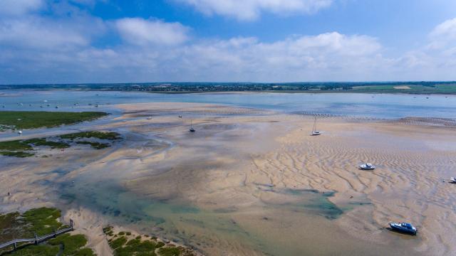 Beach with boats stranded at low tide