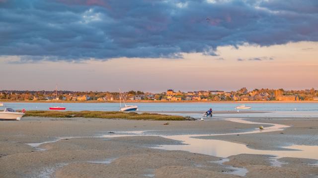 Beach with boats and people at sunset
