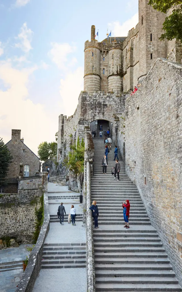 Stairs leading to a medieval castle with visitors