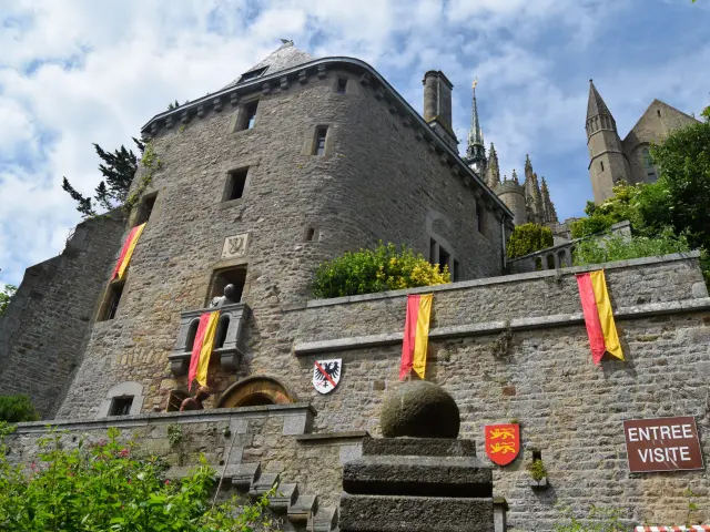 Medieval stone castle with colorful banners and an entrance sign