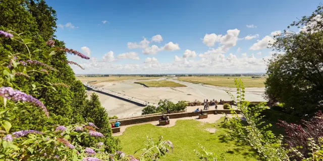 Panoramic view of an airport with runways and people walking on a path
