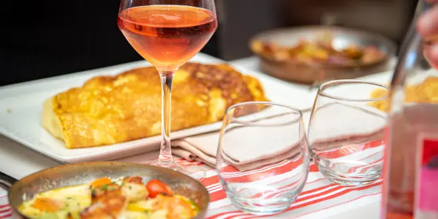 Table set with gourmet dishes and glasses of rosé wine