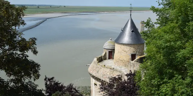 Medieval tower with conical roof by a body of water