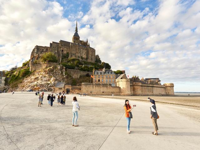 Mont Saint-Michel with visitors on the beach