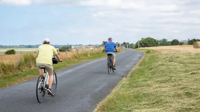 Deux personnes faisant du vélo sur une route de campagne