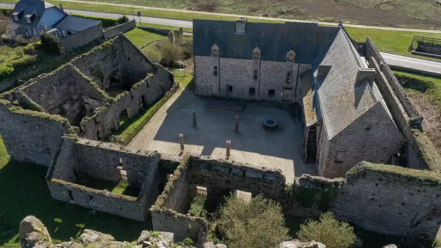 Aerial view of the ruins of a medieval castle with stone walls and a central courtyard