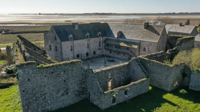 Aerial view of the ruins of a medieval castle surrounded by stone walls