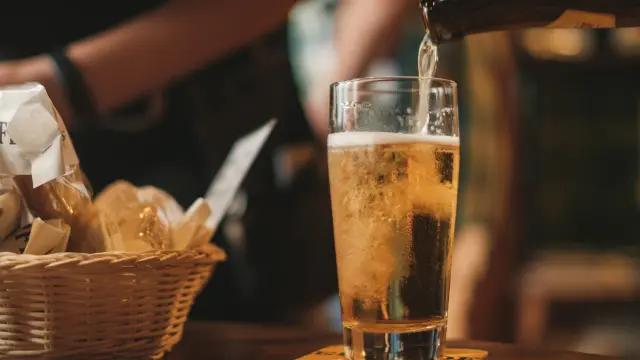 Une bière blonde pétillante est versée dans un verre transparent