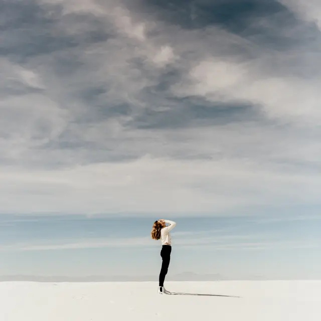 Personne debout dans un paysage enneigé sous un ciel nuageux