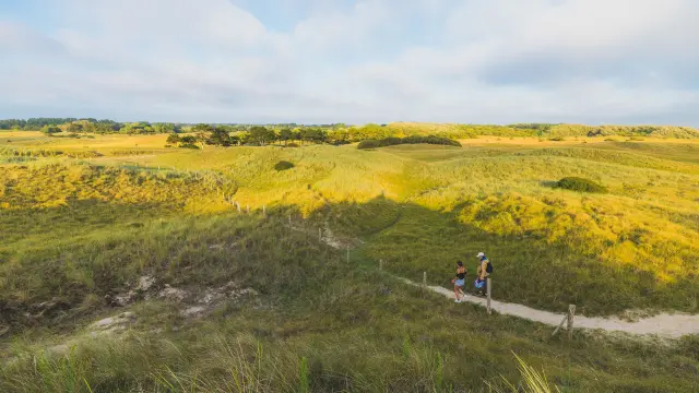 Deux personnes marchant sur un sentier dans des dunes à Annoville sur Mer