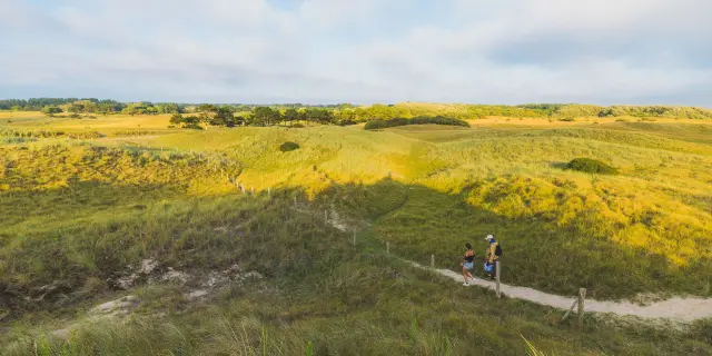 Deux personnes marchant sur un sentier dans des dunes à Annoville sur Mer