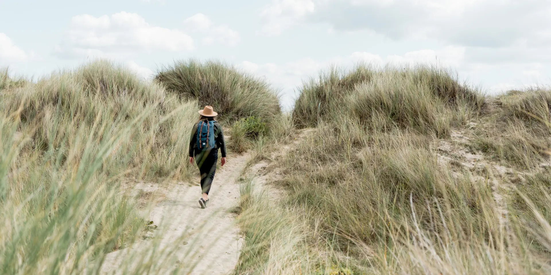Personne marchant dans un sentier entre les dunes dans le havre de Geffosses