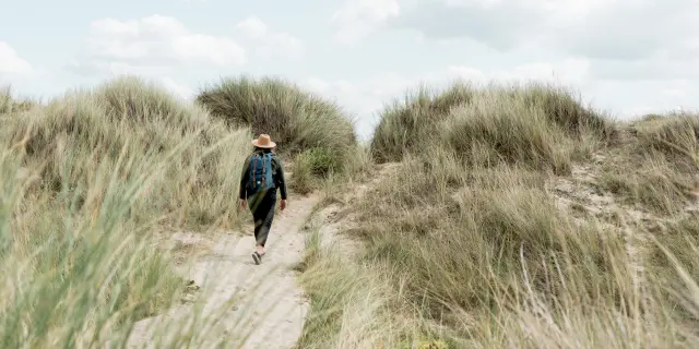 Personne marchant dans un sentier entre les dunes dans le havre de Geffosses