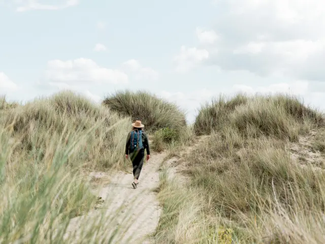 Personne marchant dans un sentier entre les dunes dans le havre de Geffosses