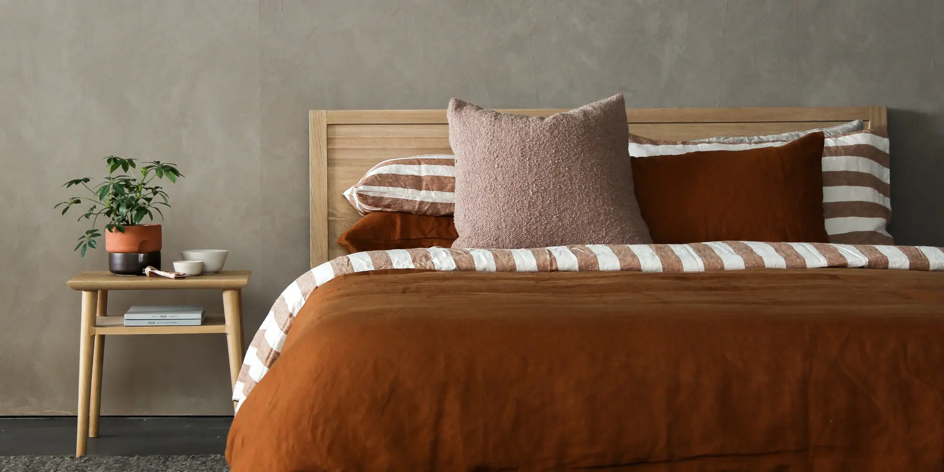 Lit avec une couverture orange et des coussins assortis
