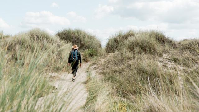 Personne marchant dans un sentier entre les dunes dans le havre de Geffosses