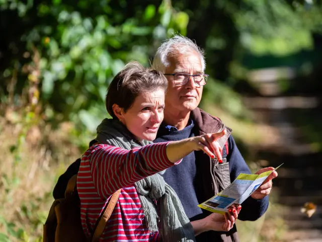 Deux randonneurs consultent un itinéraire de Coutances Tourisme