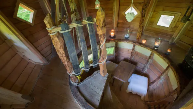 Escalier en colimaçon en bois avec des marches et des rampes en bois dans une cabane dans un arbre