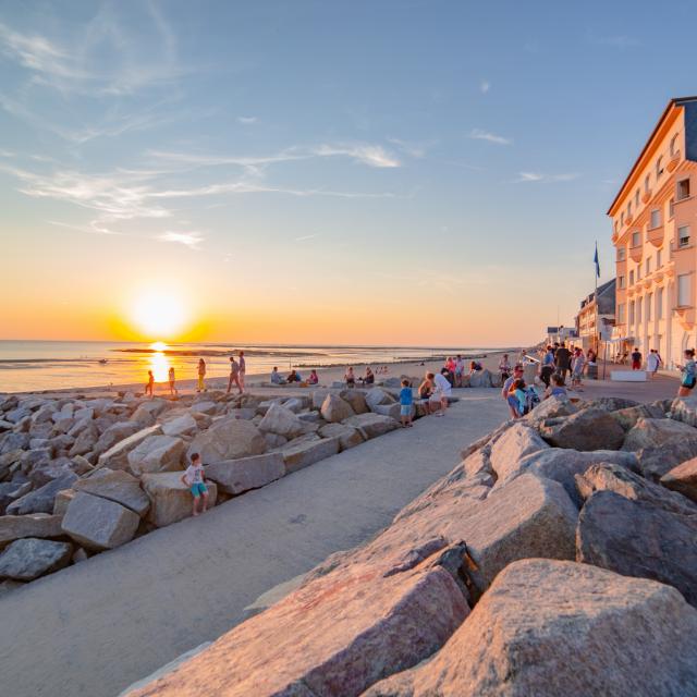 People walking on a promenade at sunset