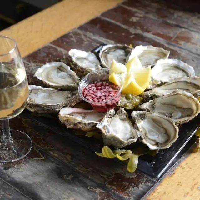 Oysters served with white wine, lemon, and cocktail sauce