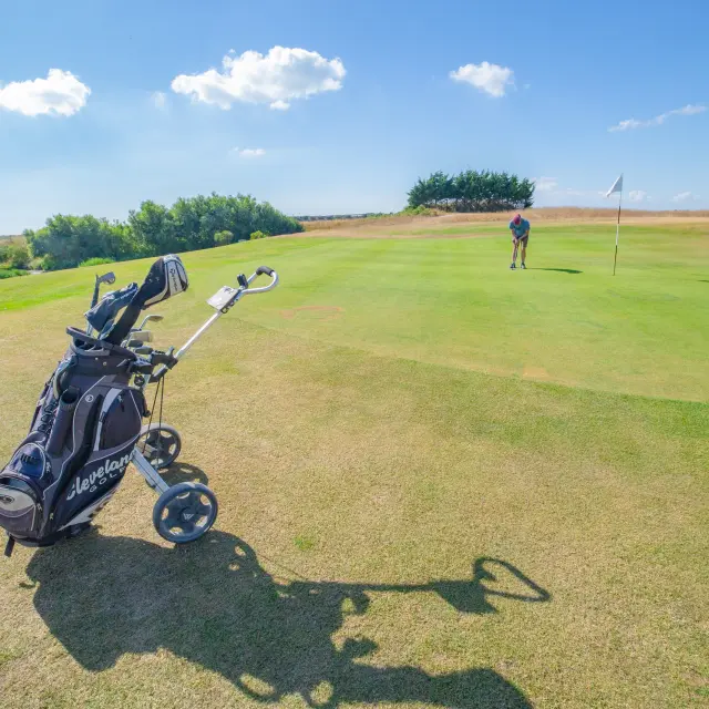 Un golfeur se prépare à frapper la balle sur un green de golf à Agon-Coutainville