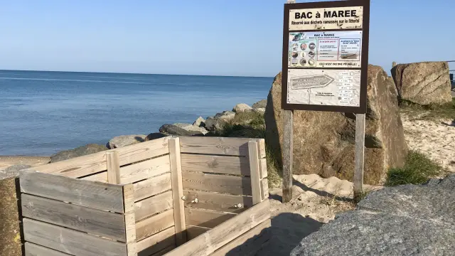 A wooden tide pool near the beach with an information sign