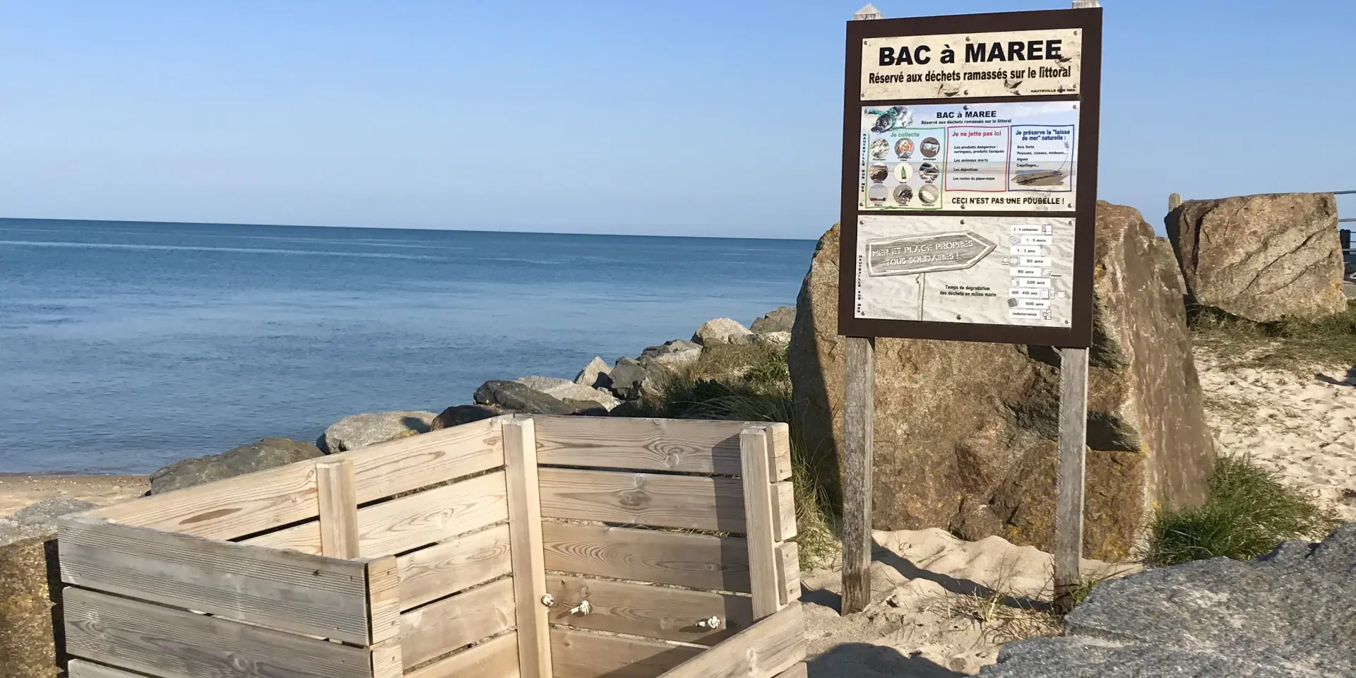 A wooden tide pool near the beach with an information sign