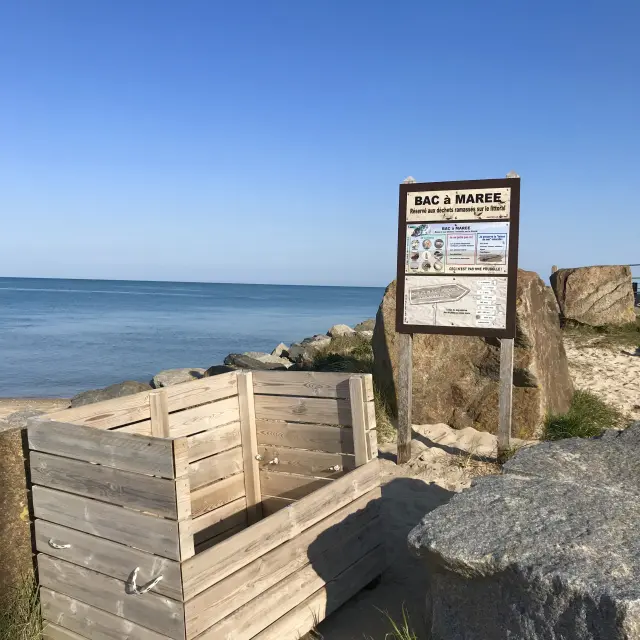 A wooden tide pool near the beach with an information sign