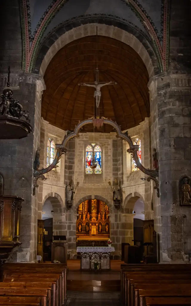 View of the interior of an old church with wooden pews and an ornate altar