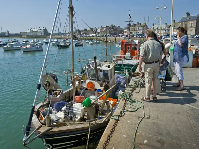 People on a harbor quay with moored boats