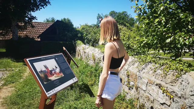 Femme en tenue d'été lisant un panneau dans la vallée des peintres de Carolles