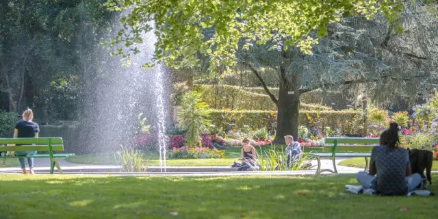 Personnes assises sur des bancs dans le jardin des plantes de Coutances