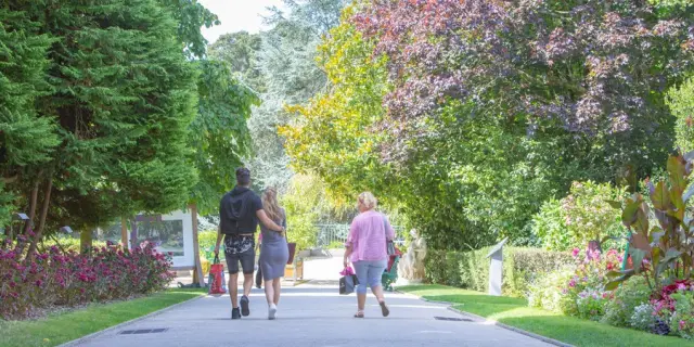 Trois personnes marchant sur un chemin au jardin des plantes de Coutances