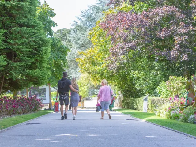 Trois personnes marchant sur un chemin au jardin des plantes de Coutances