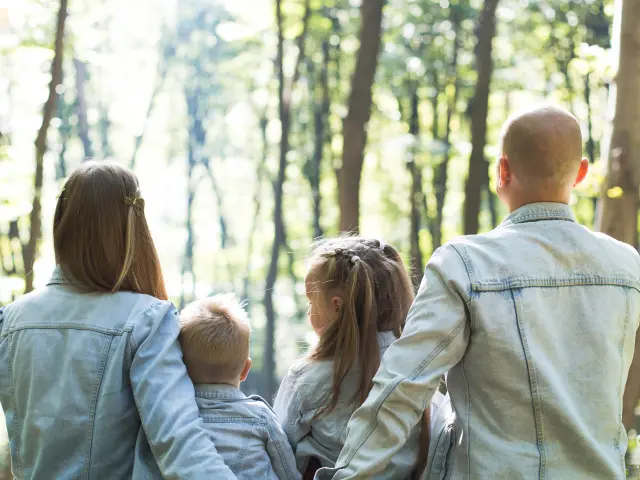 Une famille de quatre personnes assises dans une forêt