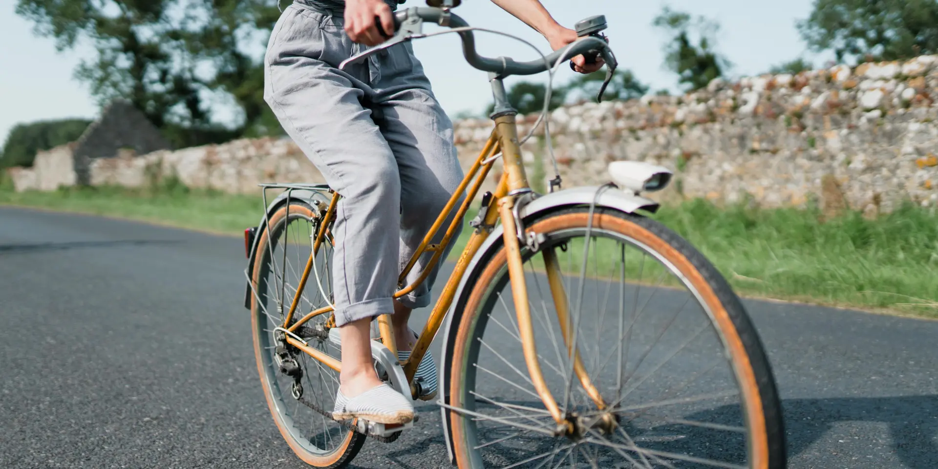 Personne pédalant sur un vélo vintage sur une route de campagne