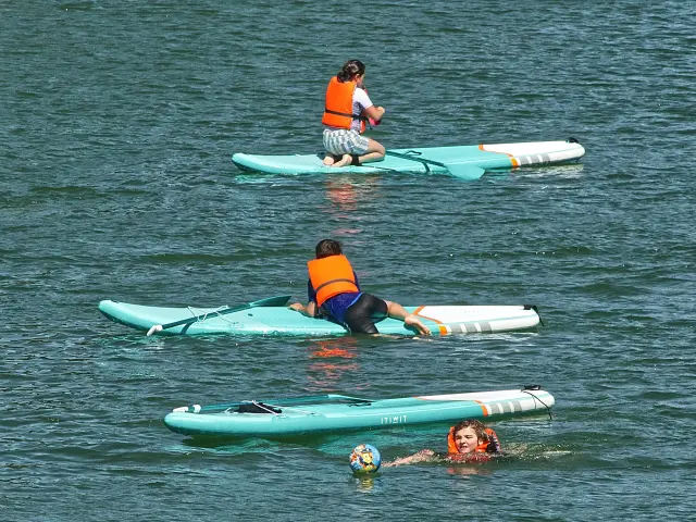 Trois personnes font du paddle en mer