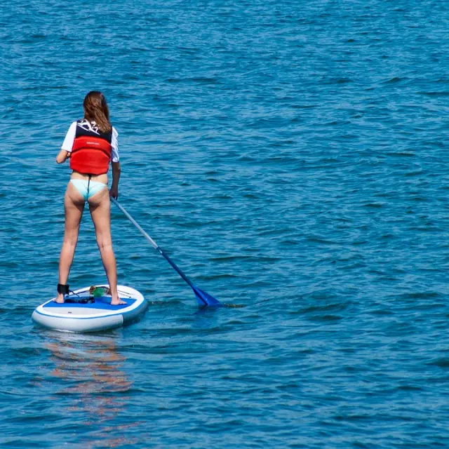 Une personne en paddleboard avec une pagaie dans l'océan