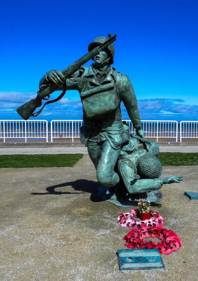 Statue d'un soldat tenant une arme et soutenant un autre soldat
