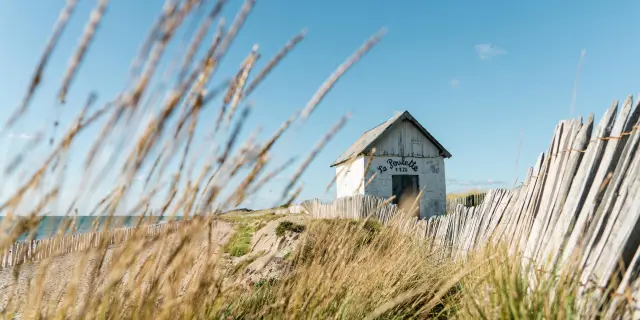 Einsames Haus umgeben von Vegetation und Zaun am Meer