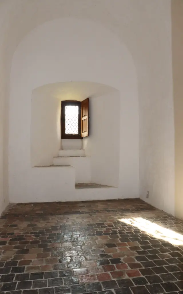 Ancienne pièce avec une fenêtre en bois et des murs blancs à de l'abbaye de Hambye
