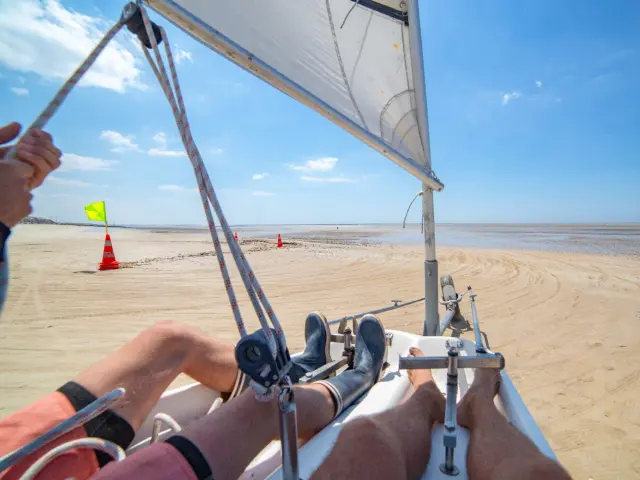 Person navigiert ein Landsegel am Strand