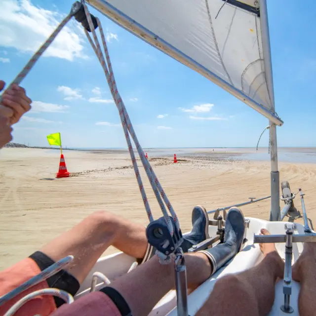 Person navigiert ein Landsegel am Strand