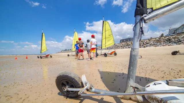 Group of people learning to use land sailers on a beach