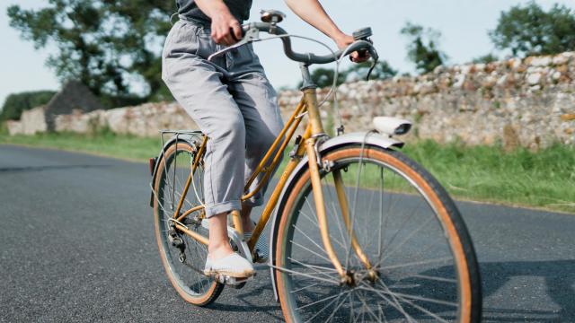 Personne pédalant sur un vélo vintage sur une route de campagne