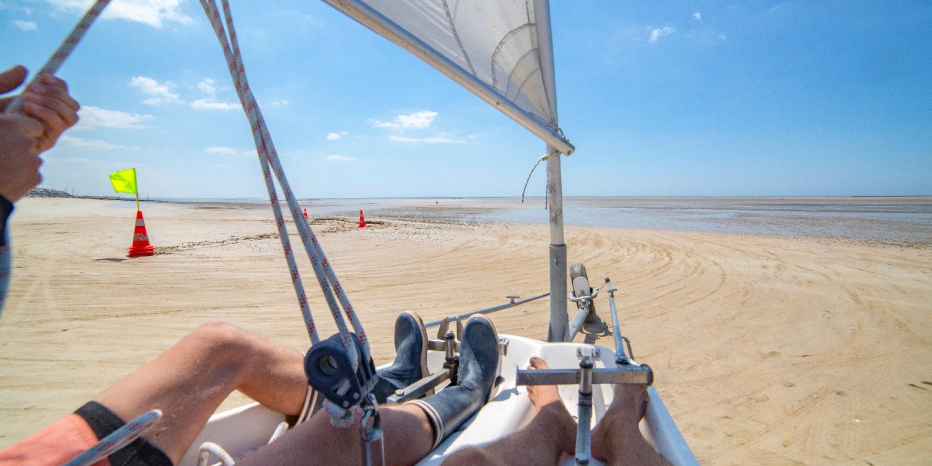 Person navigating a land sail on a beach