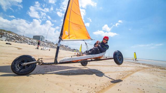 Person sailing a land yacht on a beach