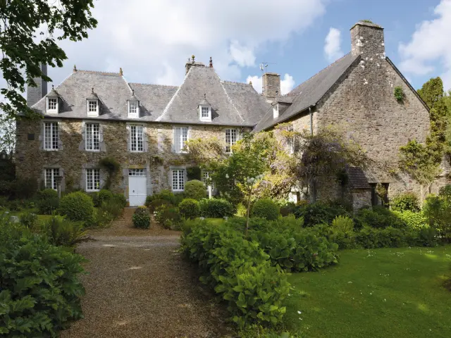 Large stone house with well-maintained garden